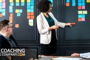 Coach with Clients brainstorming actions with sticky notes