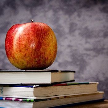 Apple on top of books