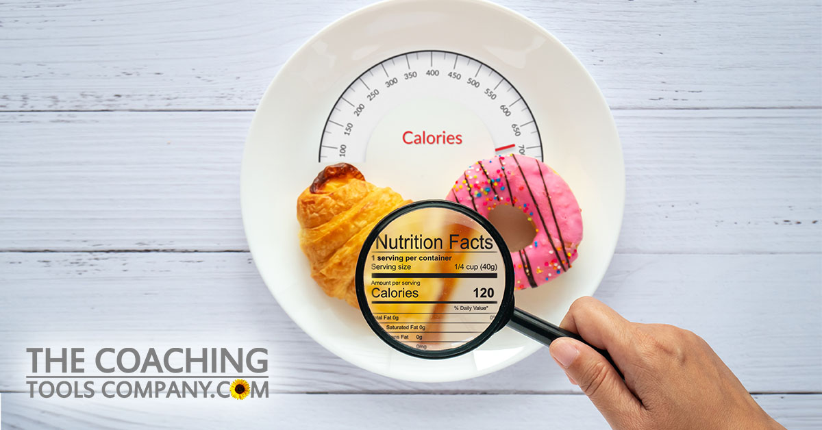 Magnifying glass on Nutrition Facts on plate with doughnut