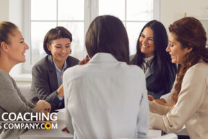 Coach and Clients sit around table for what is group coaching