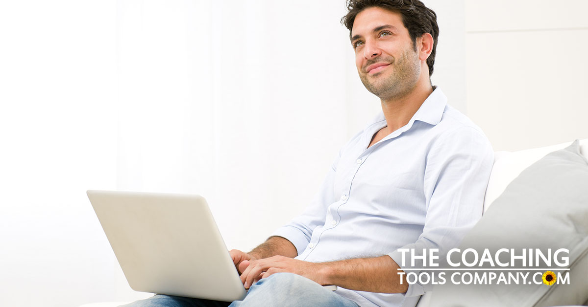 Coach considering email list on sofa with laptop