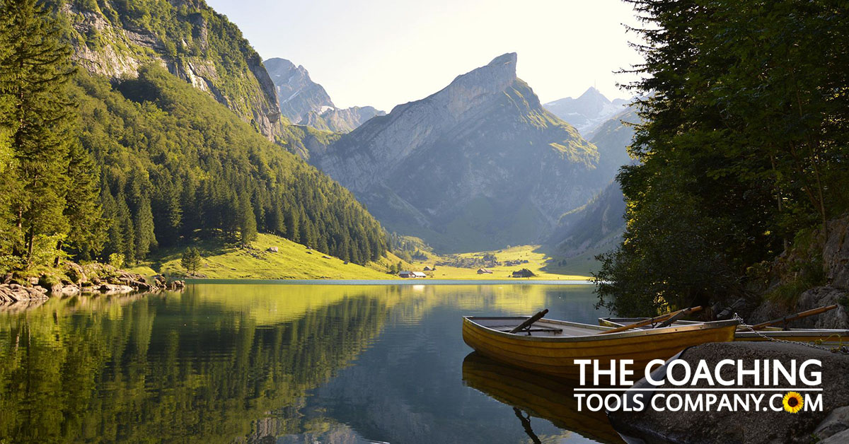 Stillness shown by mountain with lake, reflections and boat