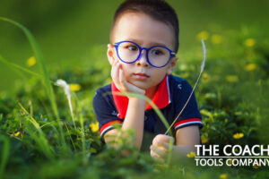 Little boy in grass in summer needing nature activities