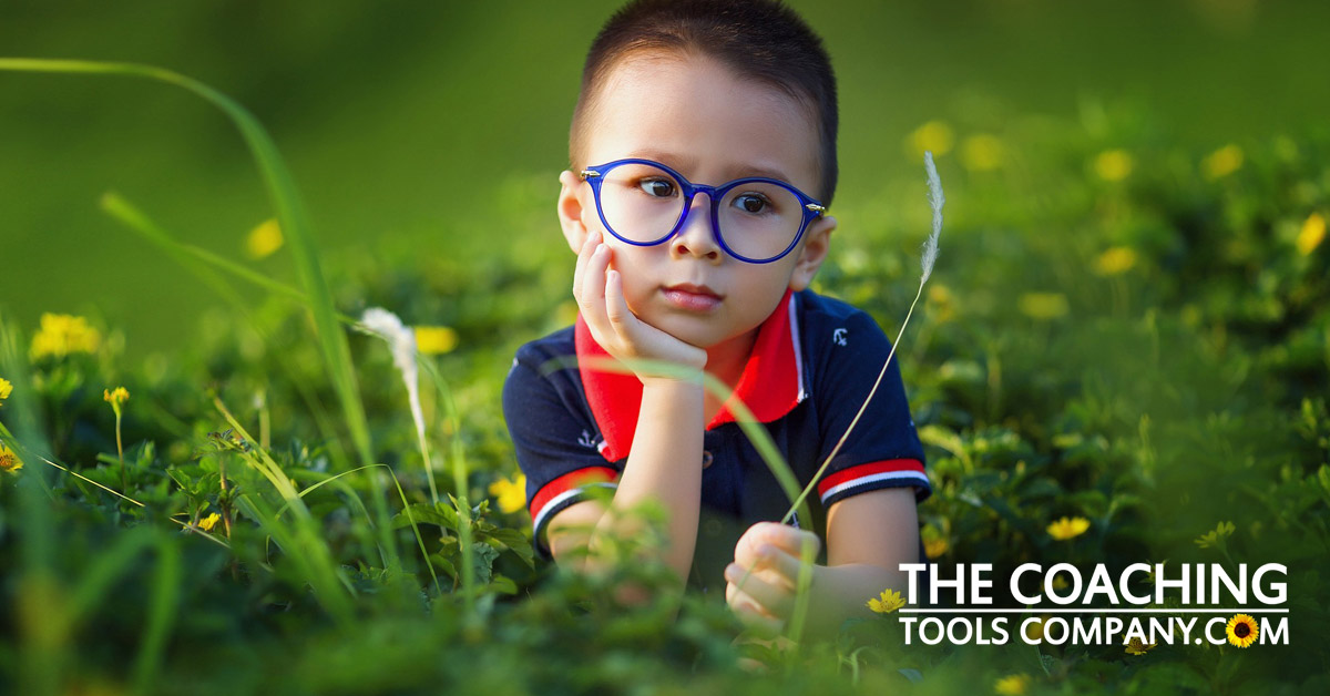 Little boy in grass in summer needing nature activities
