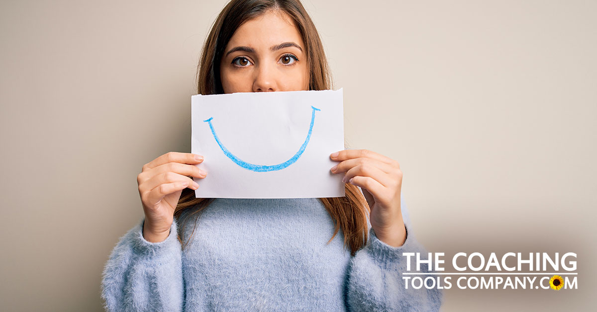 Woman with fake smile held over face who is misusing gratitude