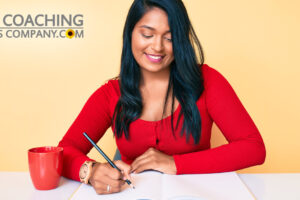Woman Journaling for Success on Desk