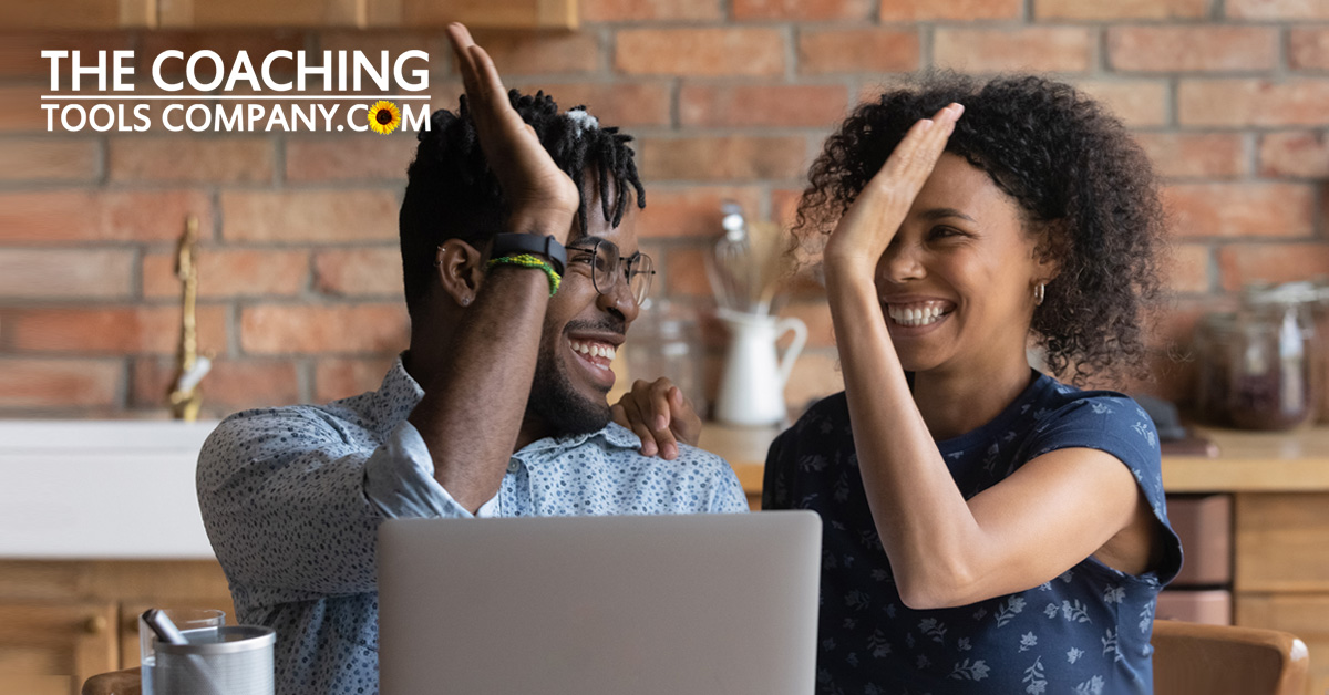 Coach and Client high-fiving in office