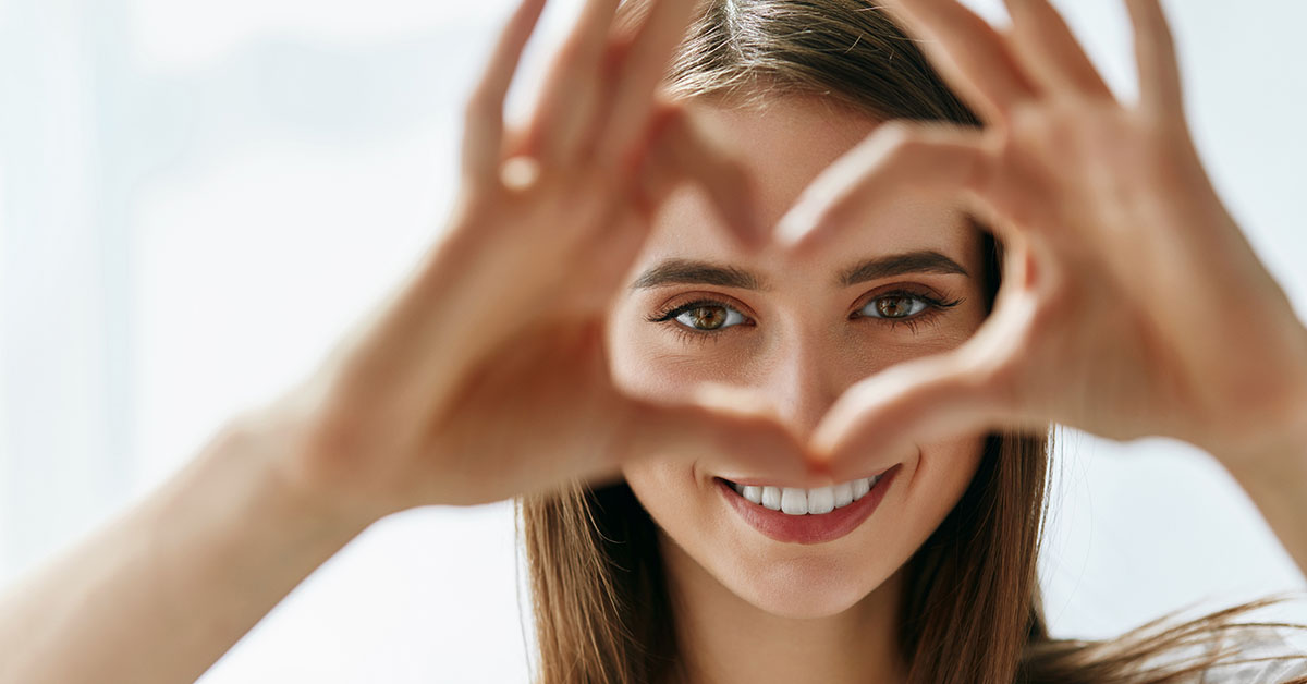 Visioning Client looking through with heart made with fingers