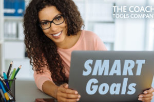 Coach peers round laptop saying SMART Goals