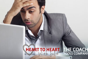 Stressed out Businessman with head in hand at desk with laptop