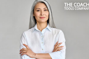 Confident, smiling older coach against grey background